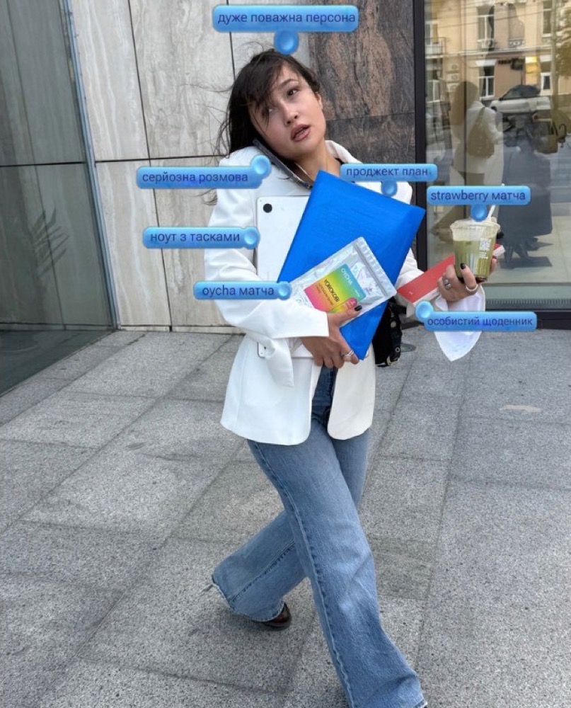 Sofia marchant en ville, veste blanche, produits OYCHA dans les bras.