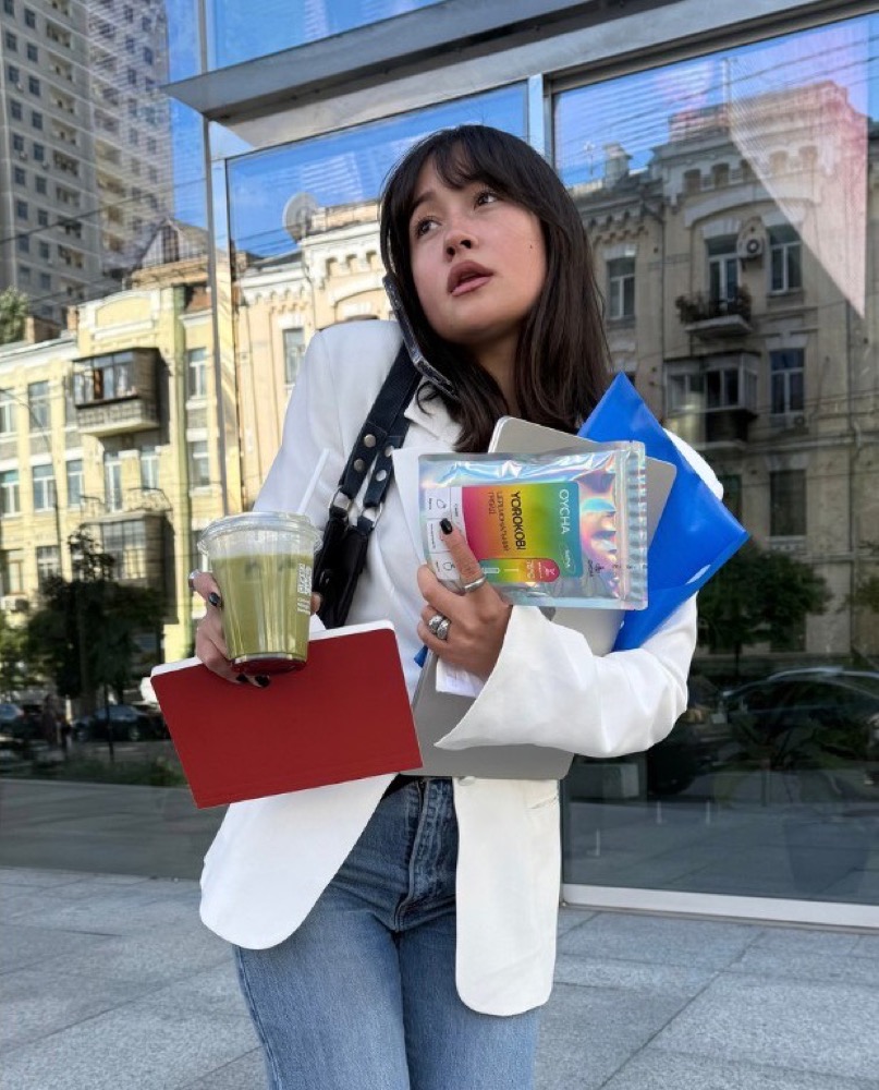 Sofia devant une vitrine, sachet OYCHA coloré à la main.
